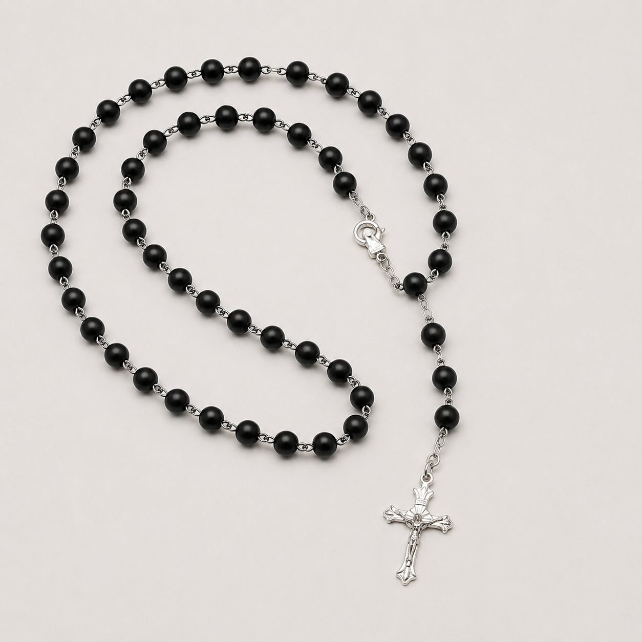 Chapelet perles noires matte crucifix argenté fond gris - Boutique Jesus
